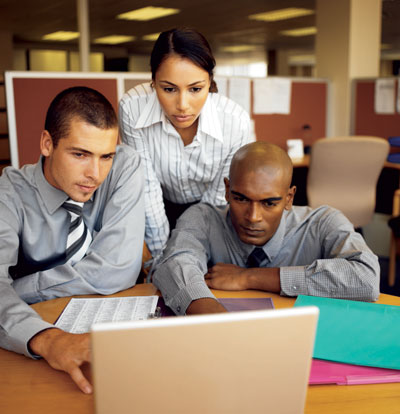 People sitting around a computer discussing